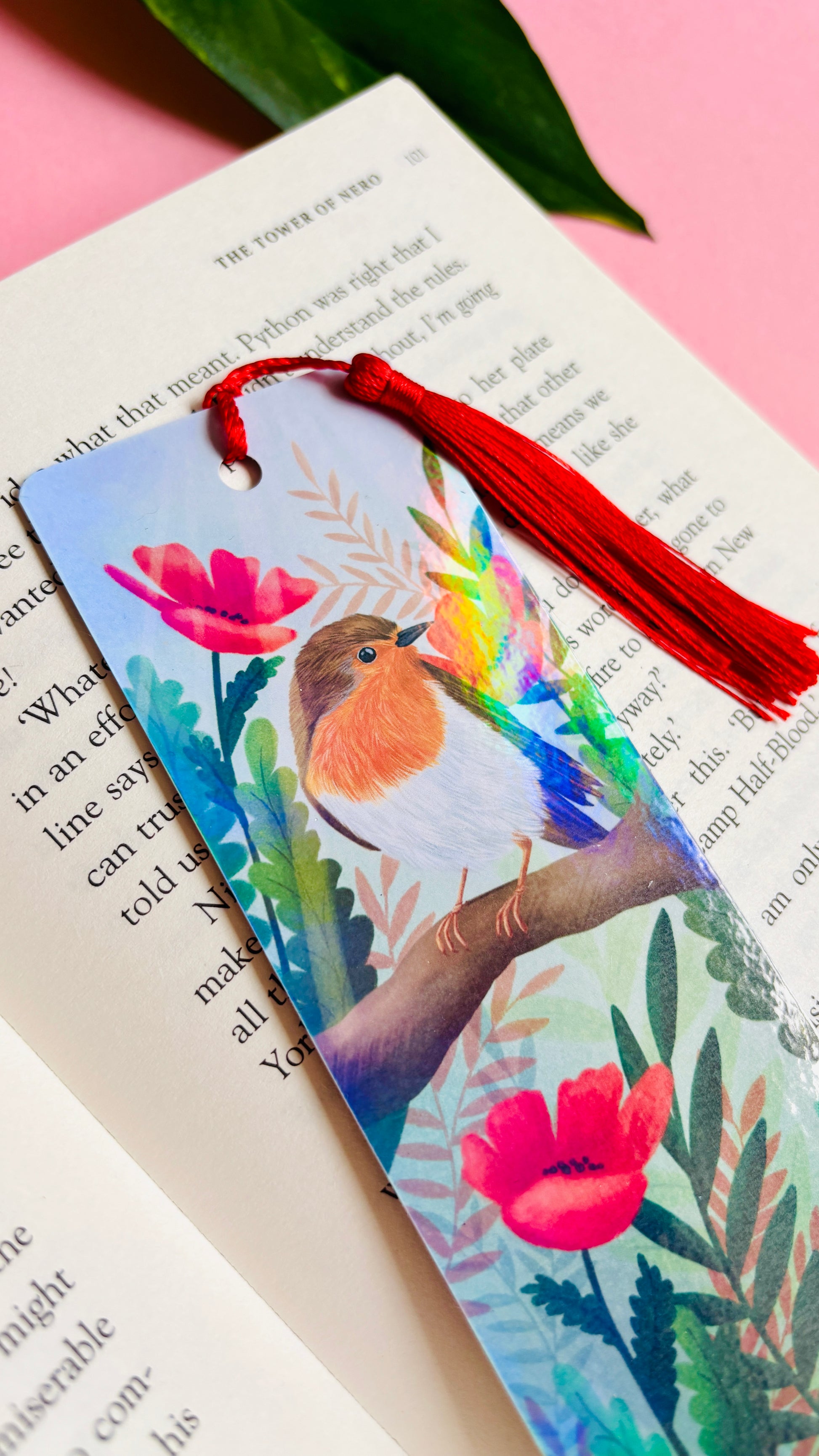 Handmade bookmark with a beautiful hand drawn illustration of a robin sitting among poppies. Finished with a rainbow holographic laminate, rounded corners and a tassel. The symbols of remembrance make this bookmark a thoughtful grief gift or way or remembering lost loved ones.