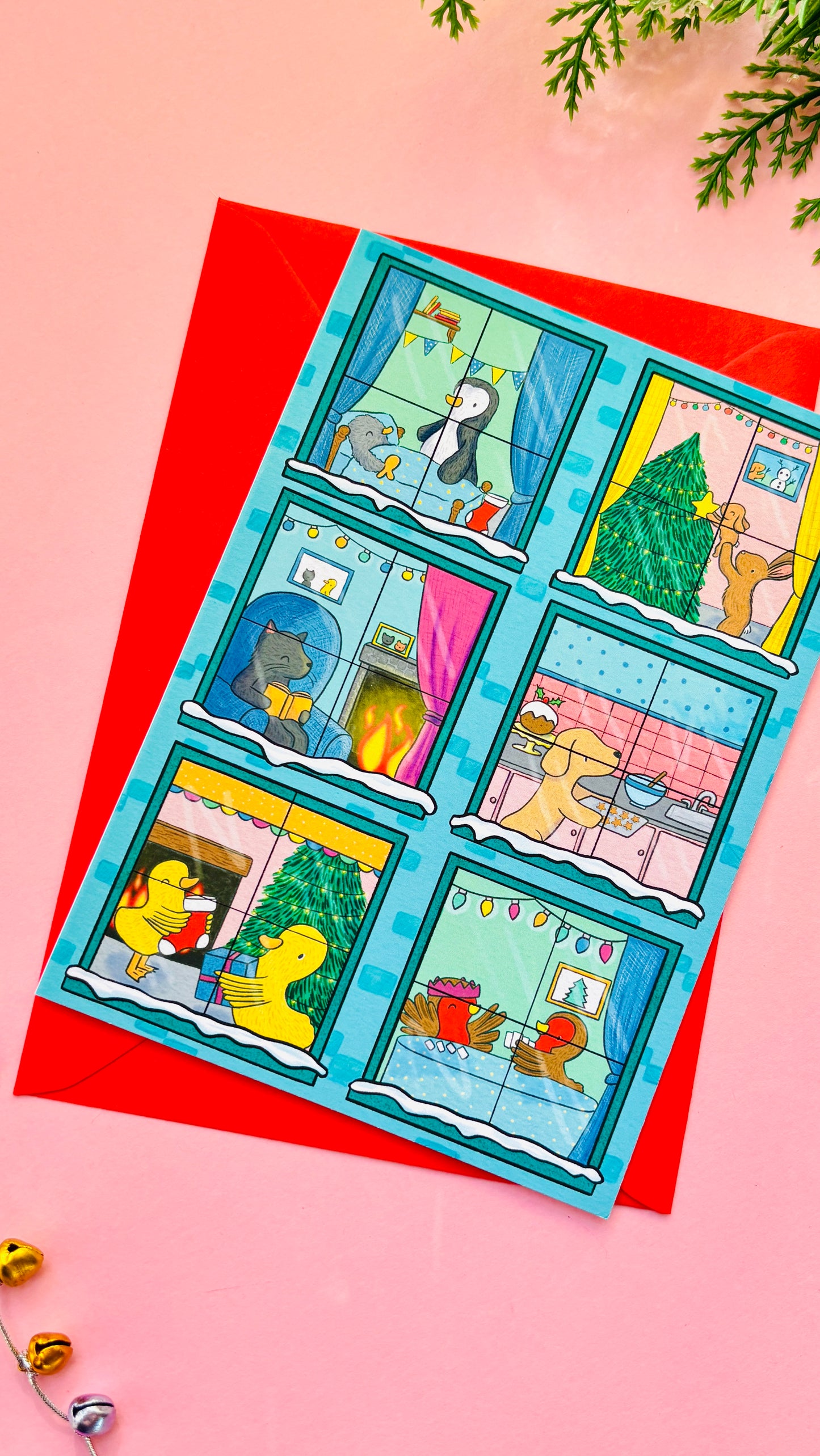 Illustrated Christmas card designed like a festive building with animals in each window, including bunnies, penguins, a cat, a dog, robins, and ducks.
