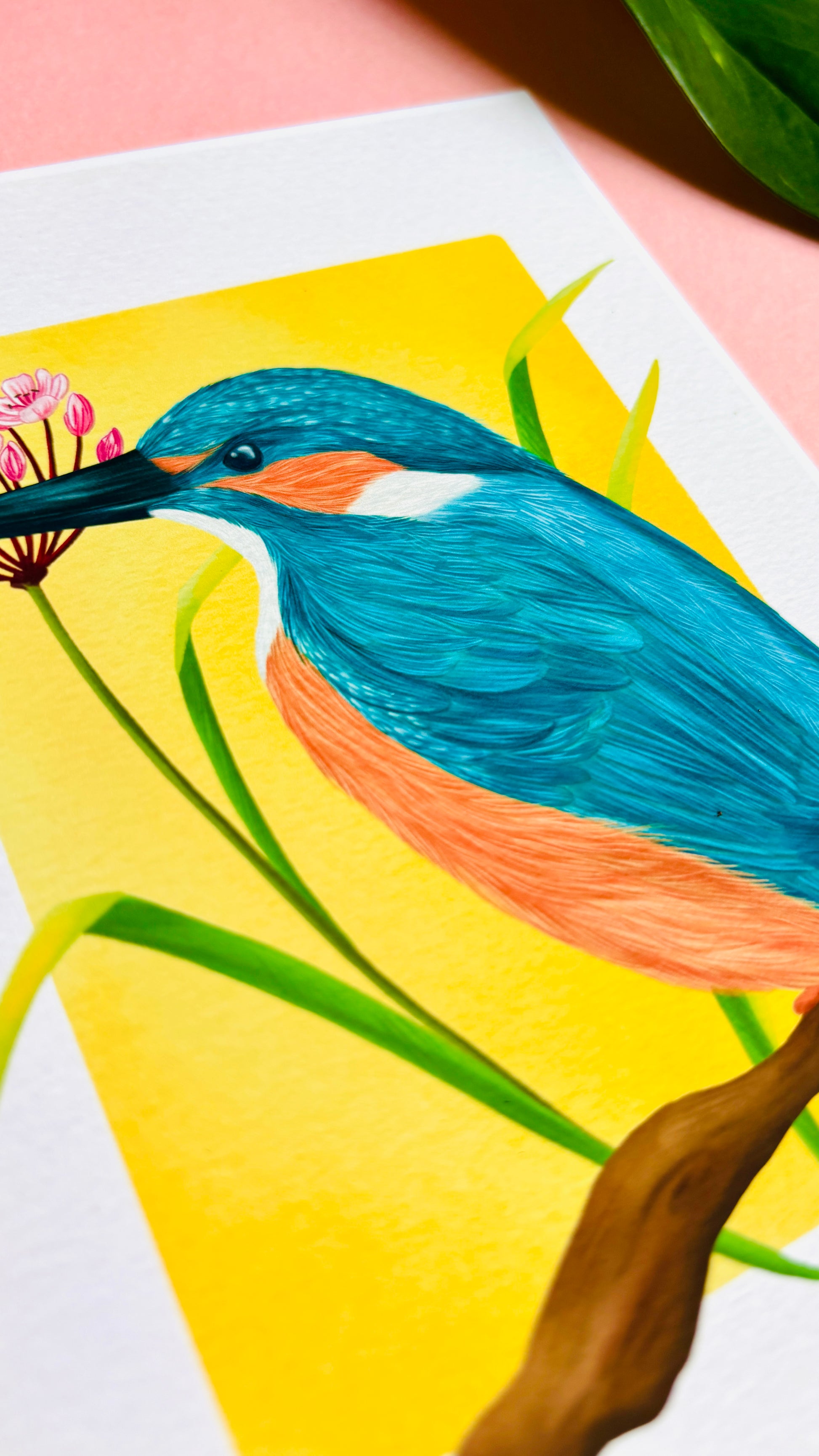 Kingfisher nature art print of a vibrant kingfisher bird and pink flowering rush plant inspired by British wildlife. Setting against a yellow backdrop this bold print is perfect for nature lovers and fans of maximalist decor.
