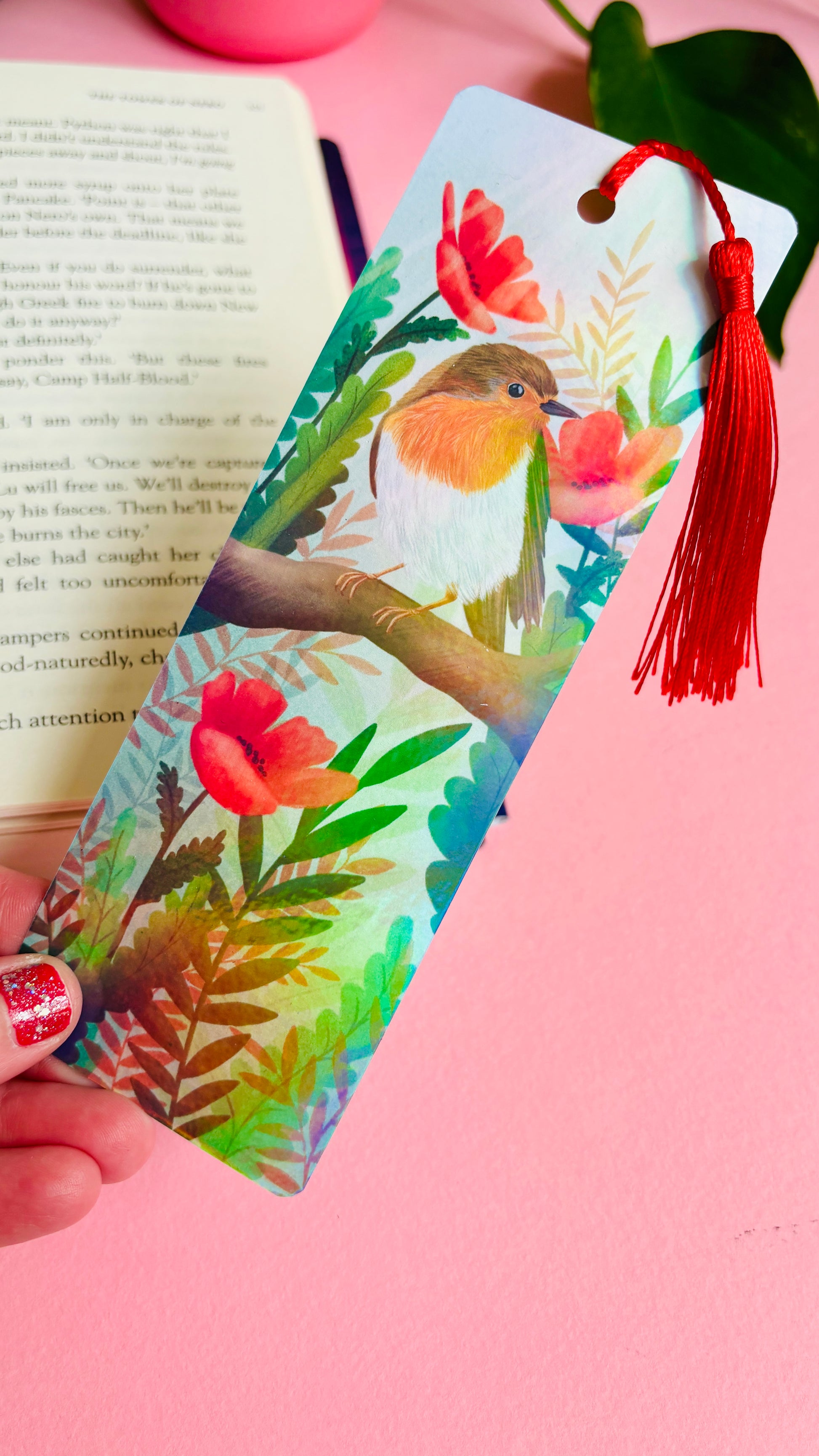 Handmade bookmark with a beautiful hand drawn illustration of a robin sitting among poppies. Finished with a rainbow holographic laminate, rounded corners and a tassel. The symbols of remembrance make this bookmark a thoughtful grief gift or way or remembering lost loved ones.