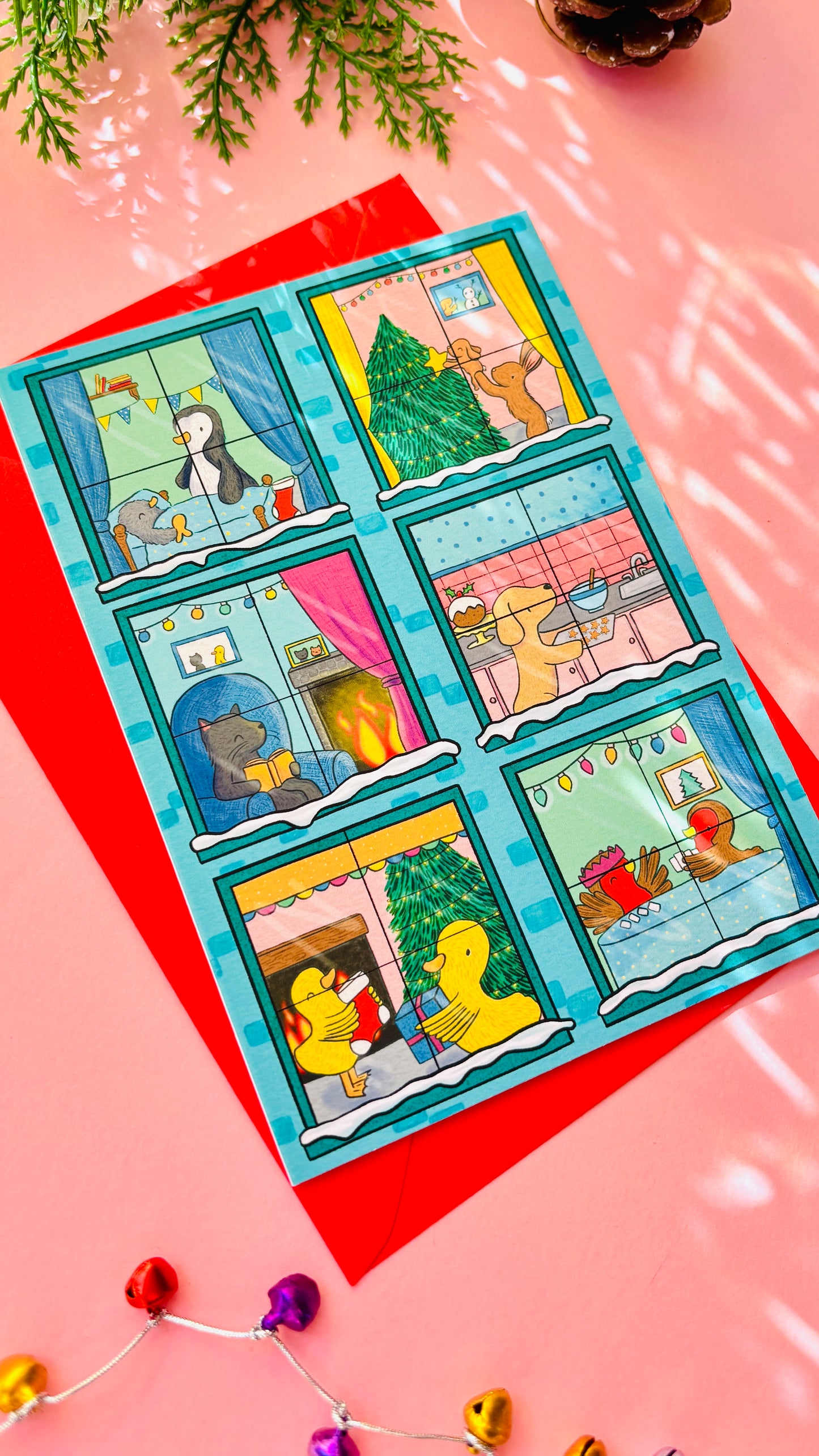 Illustrated Christmas card designed like a festive building with animals in each window, including bunnies, penguins, a cat, a dog, robins, and ducks.
