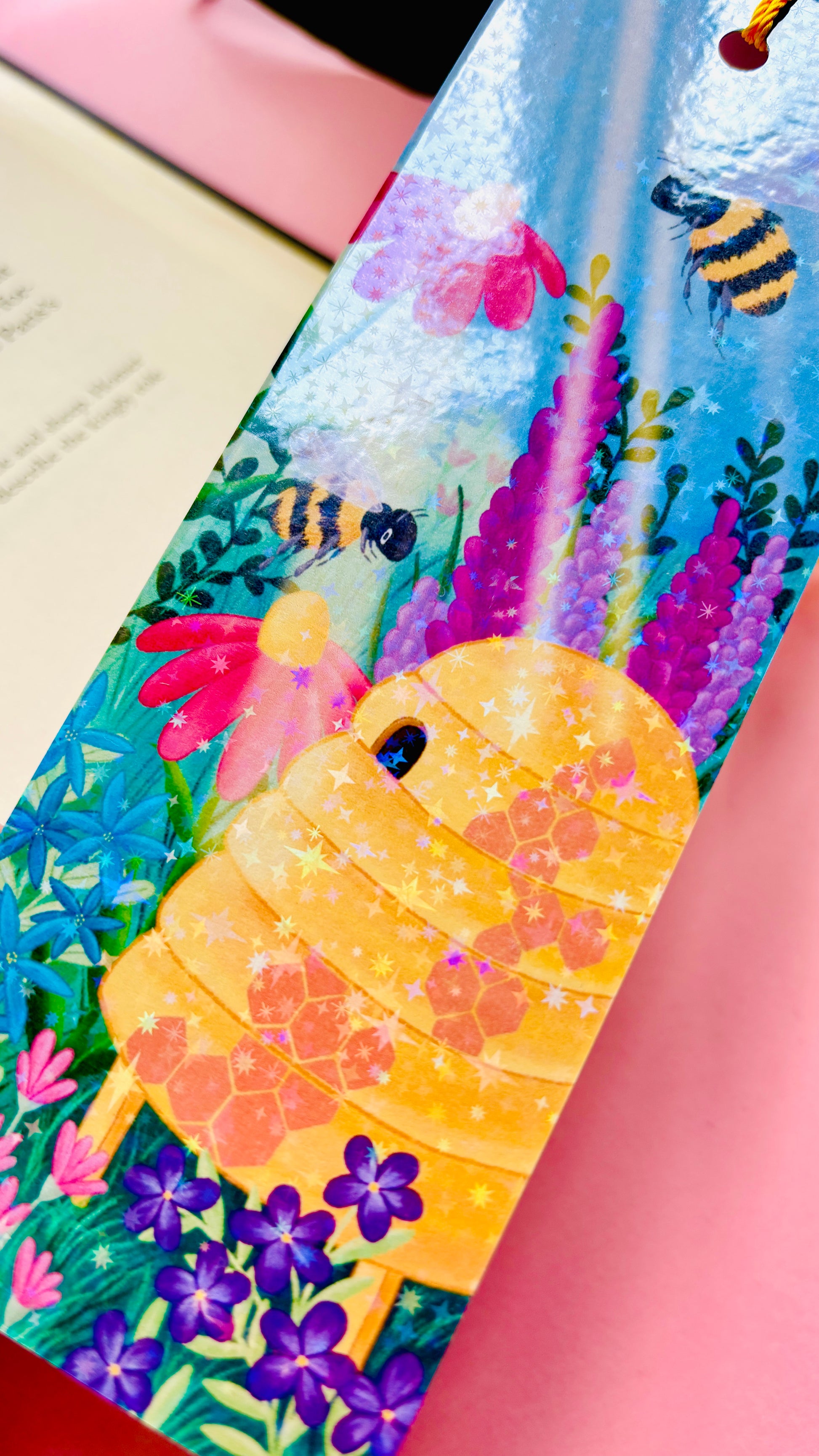 Rainbow holographic bee bookmark with whimsical wildflower meadow design, handmade in the UK, great for gifts, journals, and books.
