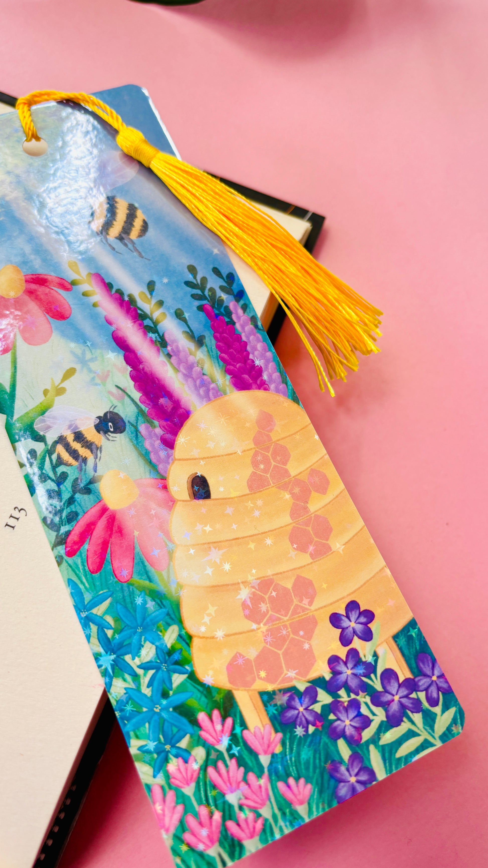 Hand-illustrated wildflower and bee bookmark, eco-friendly FSC-certified cardstock, double-sided design with holographic laminate for durability.