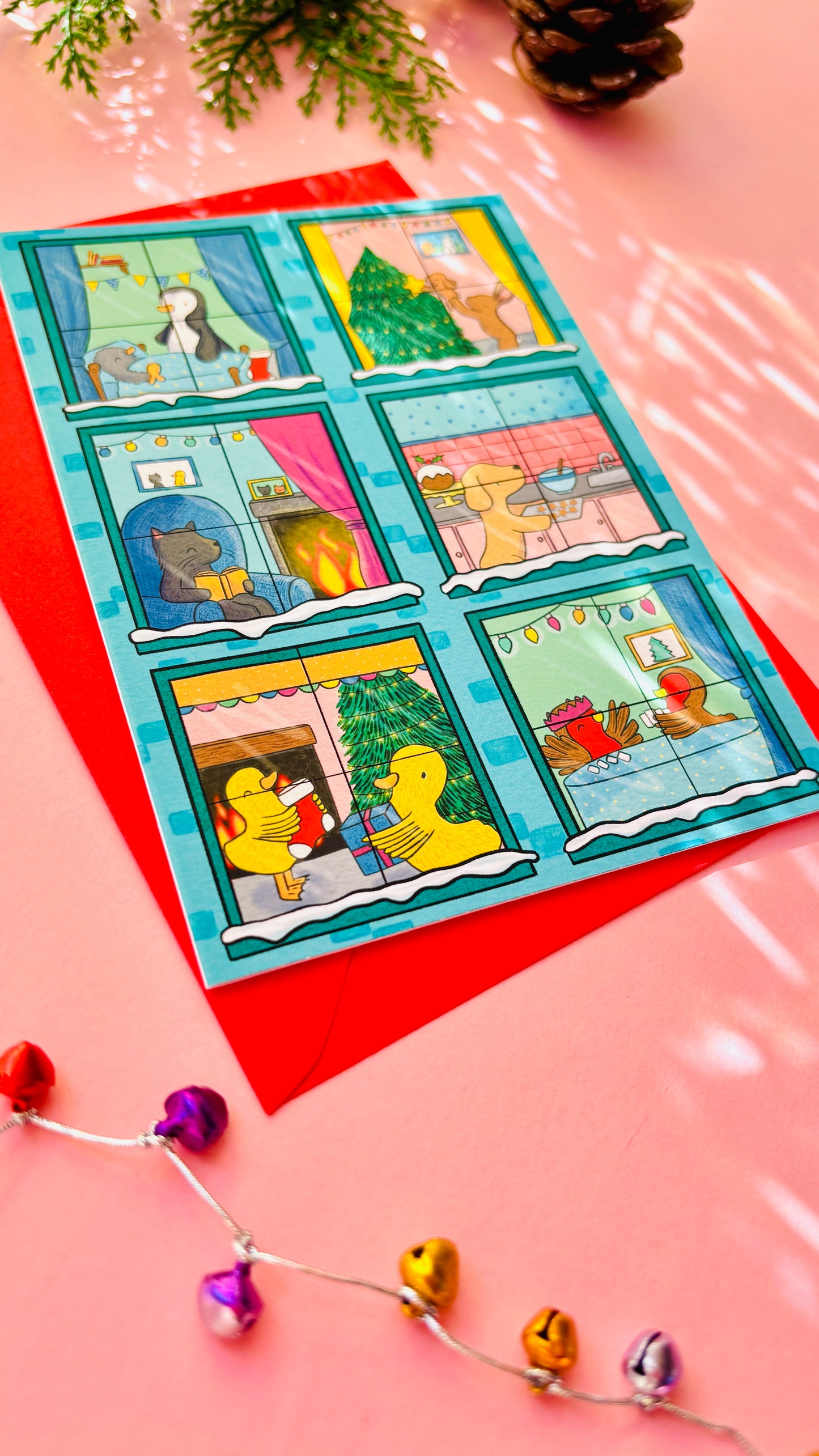 Illustrated Christmas card designed like a festive building with animals in each window, including bunnies, penguins, a cat, a dog, robins, and ducks.