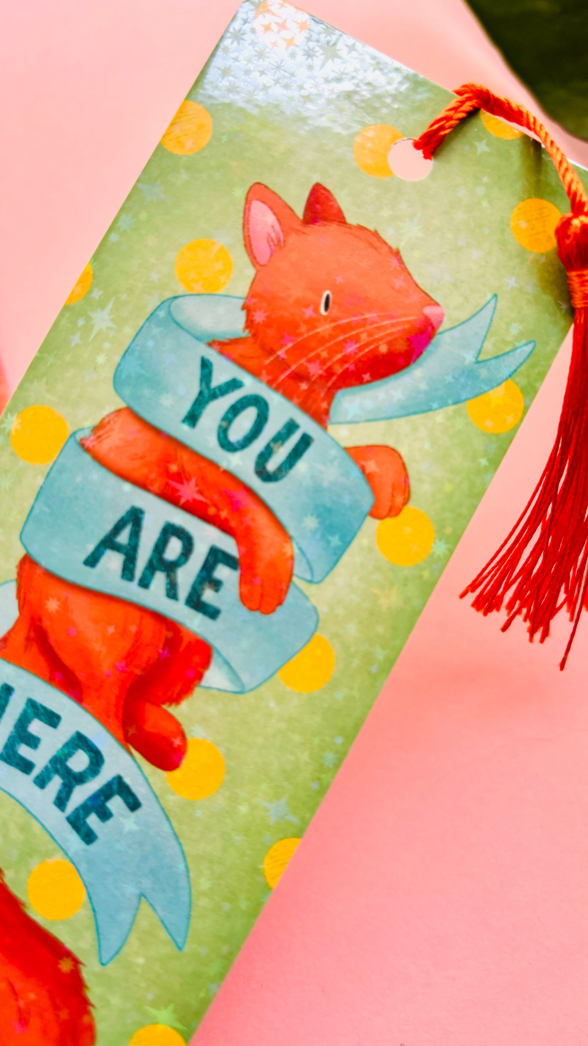 Colorful holographic ginger cat bookmark with playful green polka dots and orange tassel, handmade FSC-certified paper accessory for cat lovers, bookworms, and journaling fans.