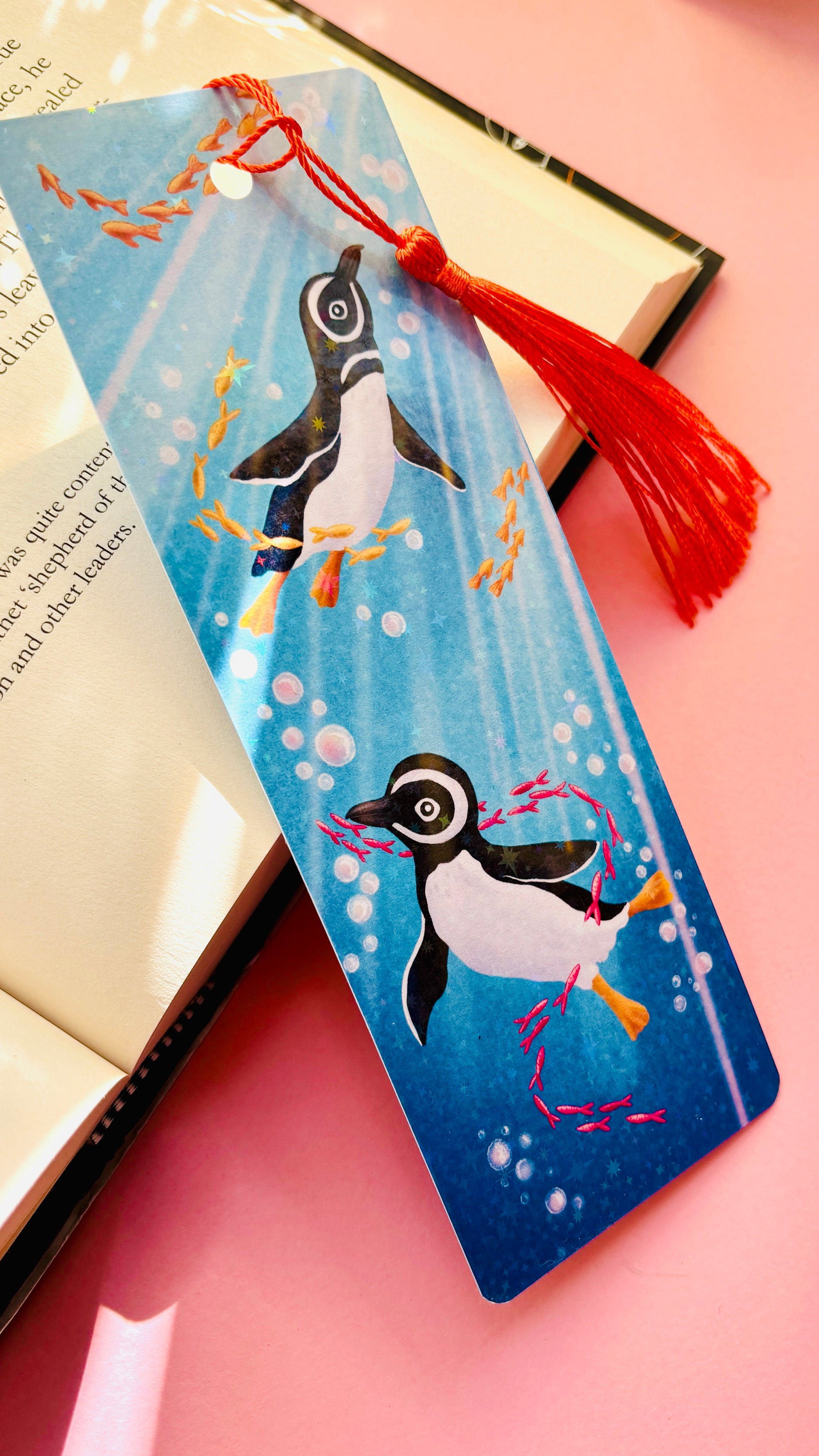 Hand-illustrated ocean bookmark featuring Humboldt penguins and colorful fish, rainbow holographic laminate, great for journals, planners, and books.