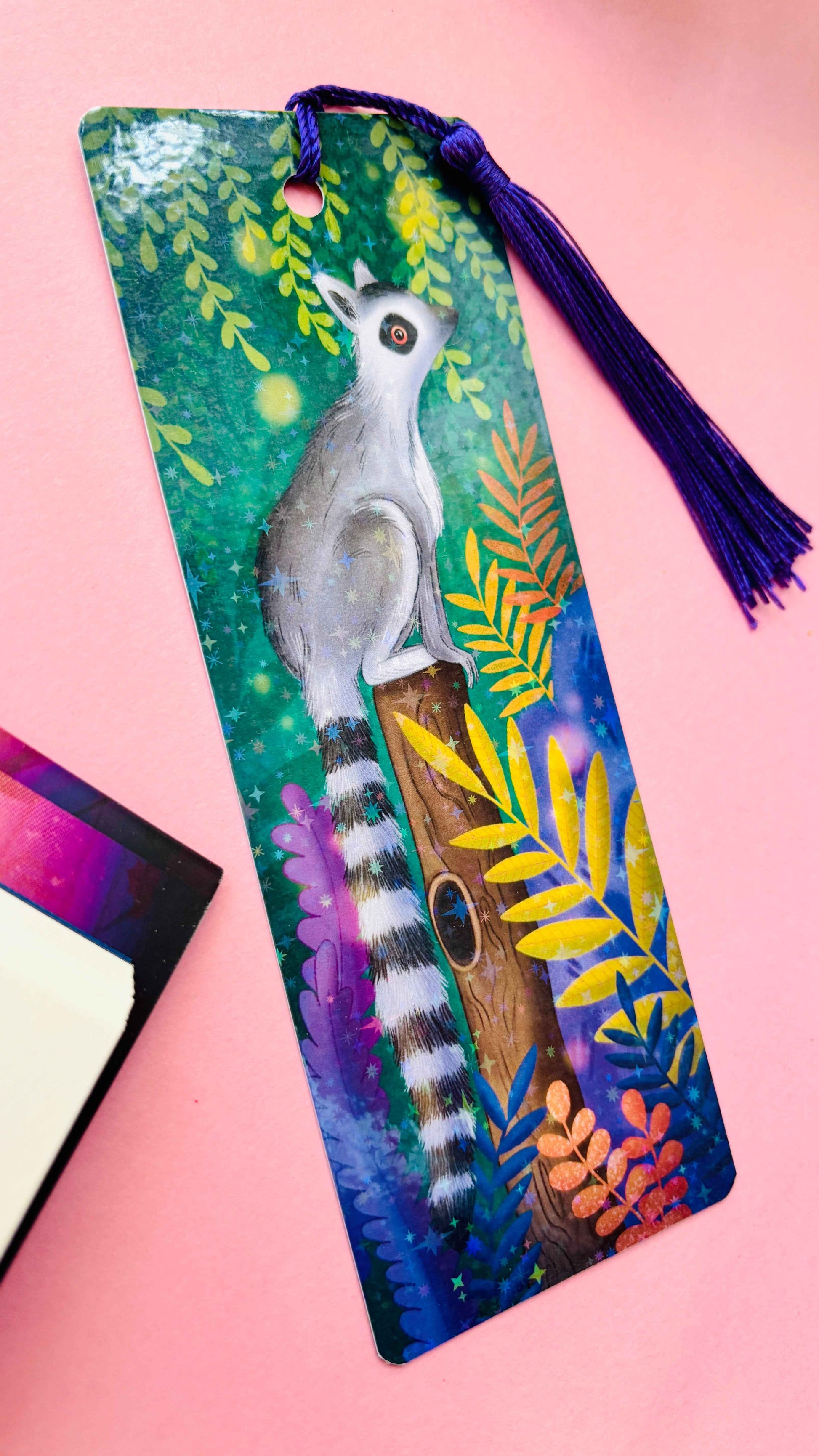 Hand-illustrated tropical lemur bookmark with holographic finish and tassel – sustainable, handmade in the UK.