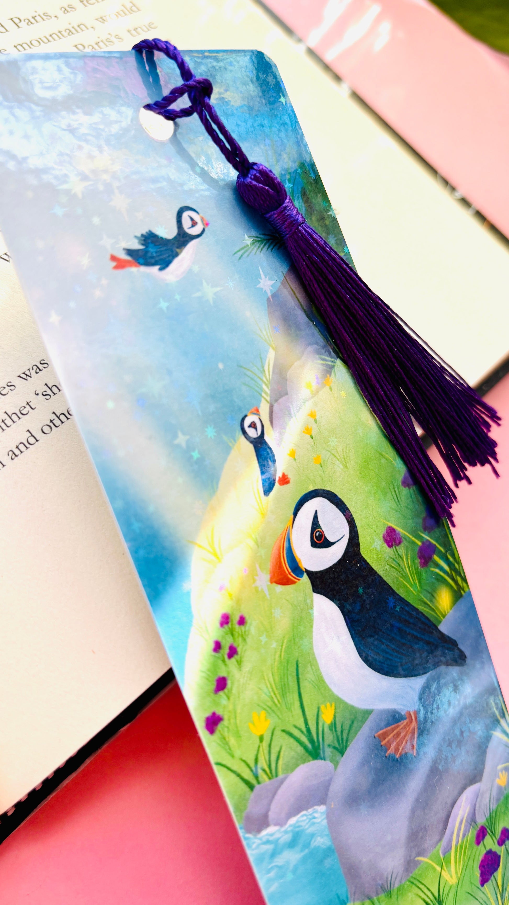 Colorful holographic puffin bookmark with seaside background and tassel, handmade FSC-certified paper accessory for puffin fans, bookworms, and journaling enthusiasts.