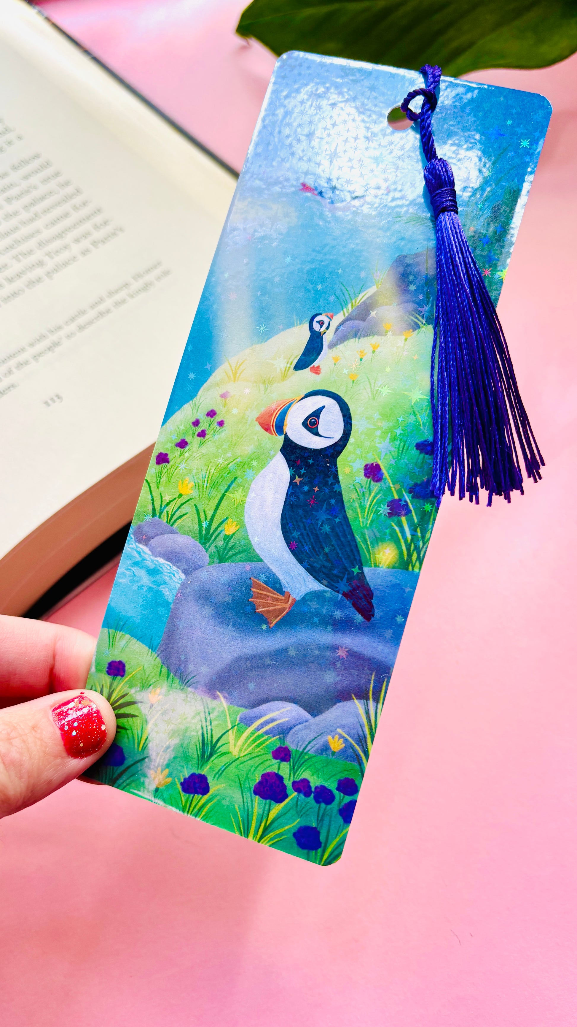 Colorful holographic puffin bookmark with seaside background and tassel, handmade FSC-certified paper accessory for puffin fans, bookworms, and journaling enthusiasts.
