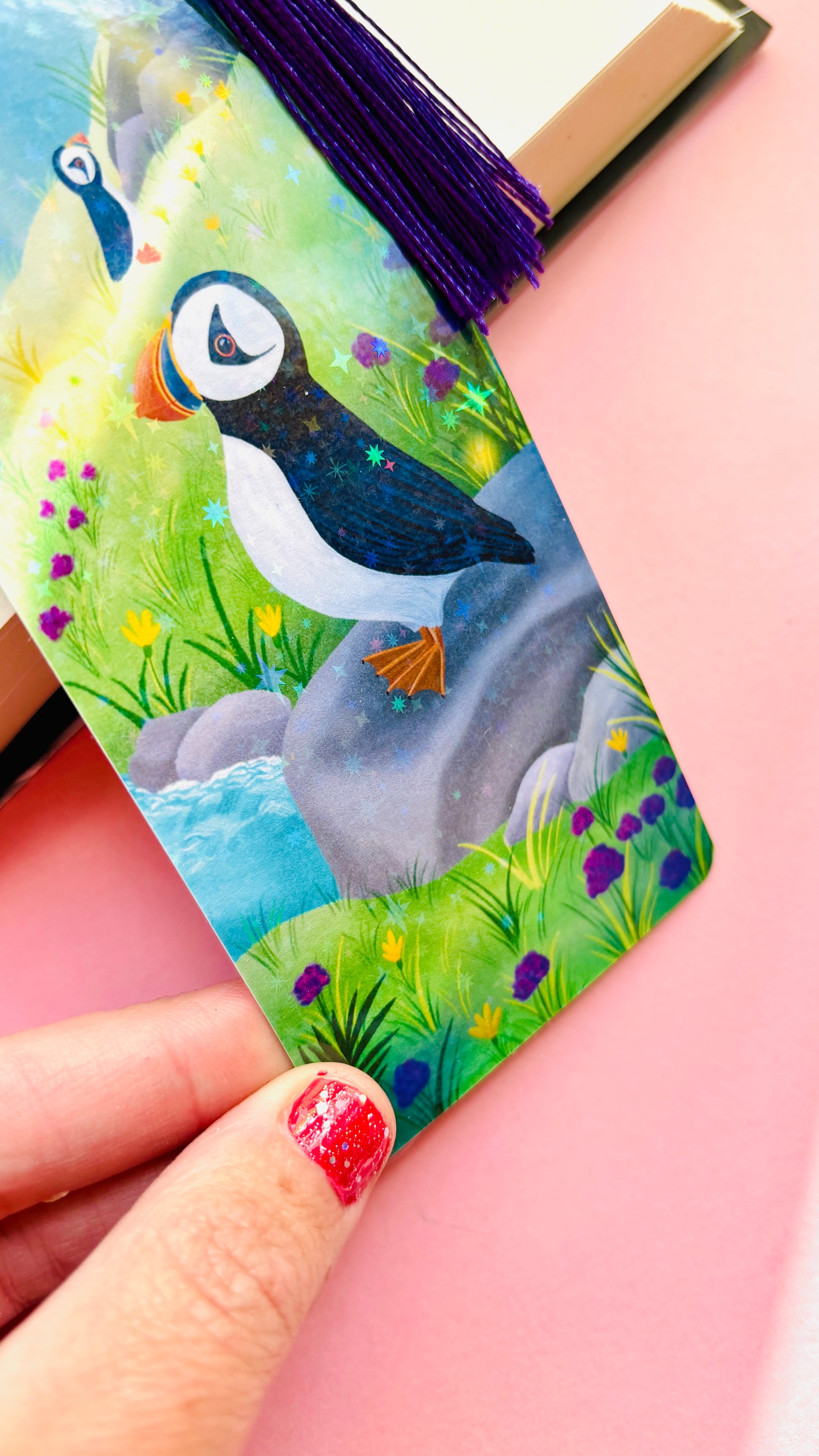 Cute puffin bookmark with rainbow holographic shimmer, coastal seaside illustration, and coordinating tassel, handmade in the UK for bird lovers and book enthusiasts.