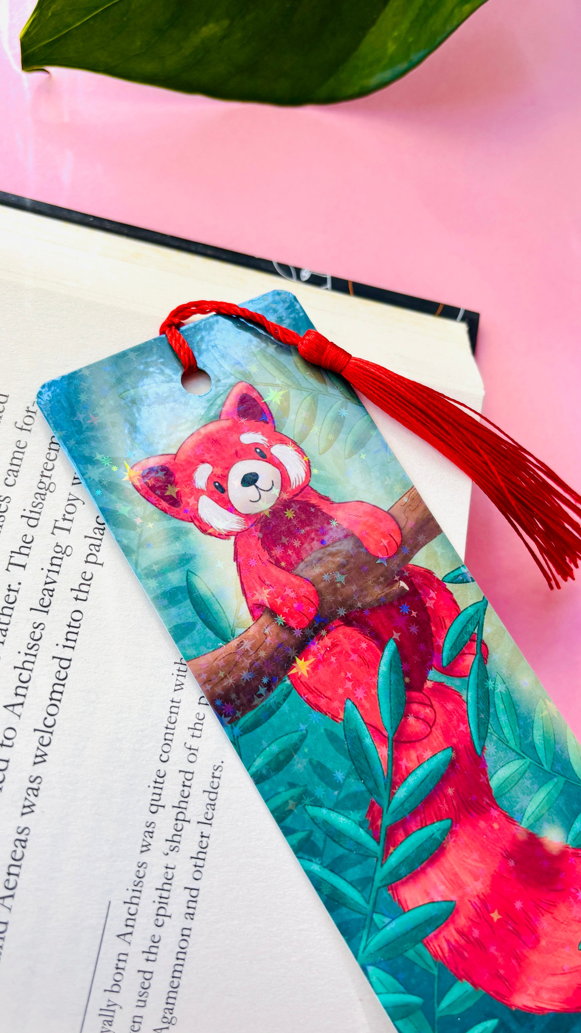 Hand-illustrated red panda gift bookmark with rainbow holographic finish and green tassel – double-sided, eco-friendly 300gsm cardstock, handmade UK gift for book lovers.