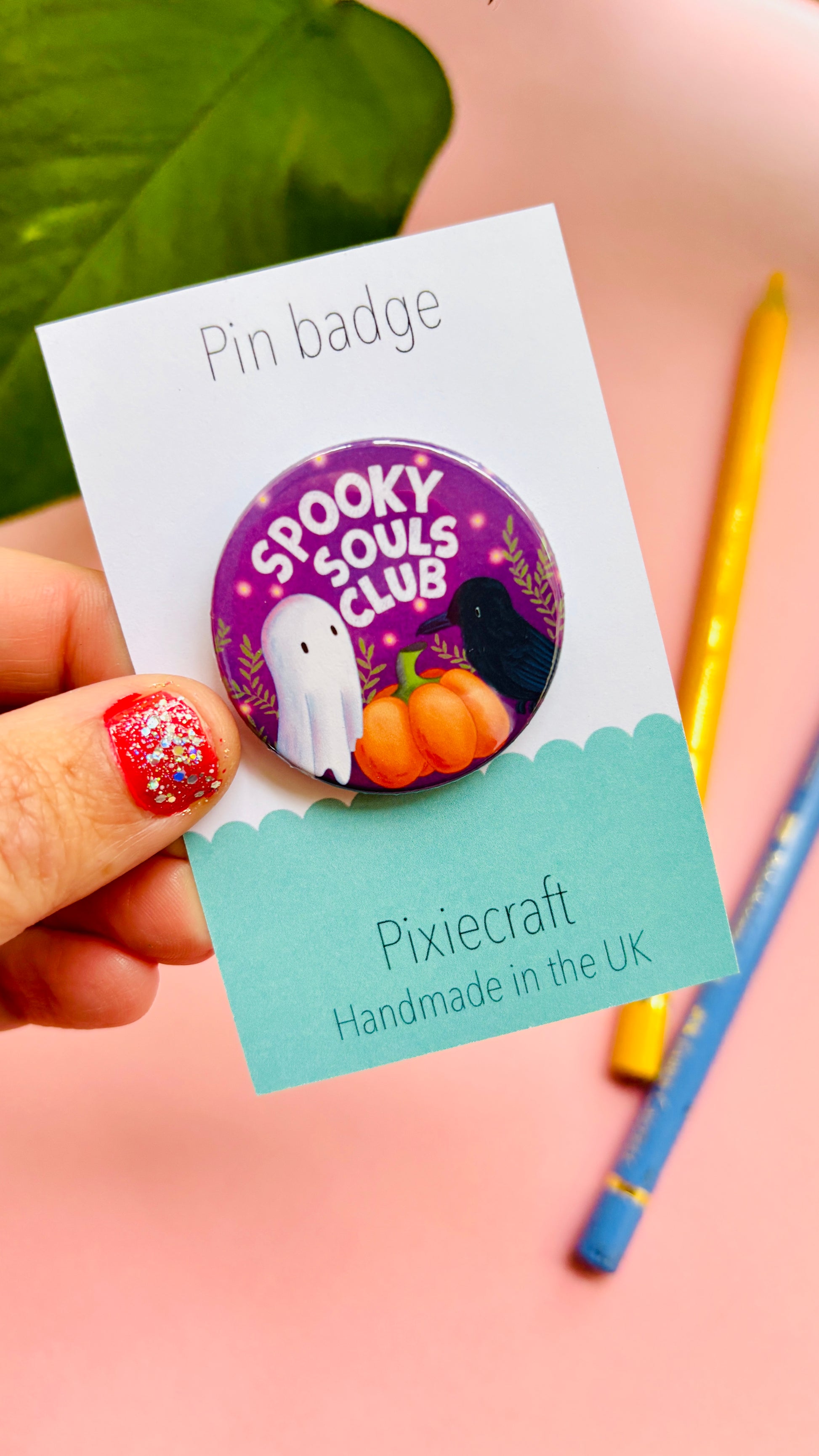 Cute Halloween accessory pin badge that reads “Spooky souls club” above a cute ghost, pumpkin and raven. A 38mm round pin presented on a backing card this badge or magnet is a great gift for Halloween treats, alt style accessories, witchy aesthetics.