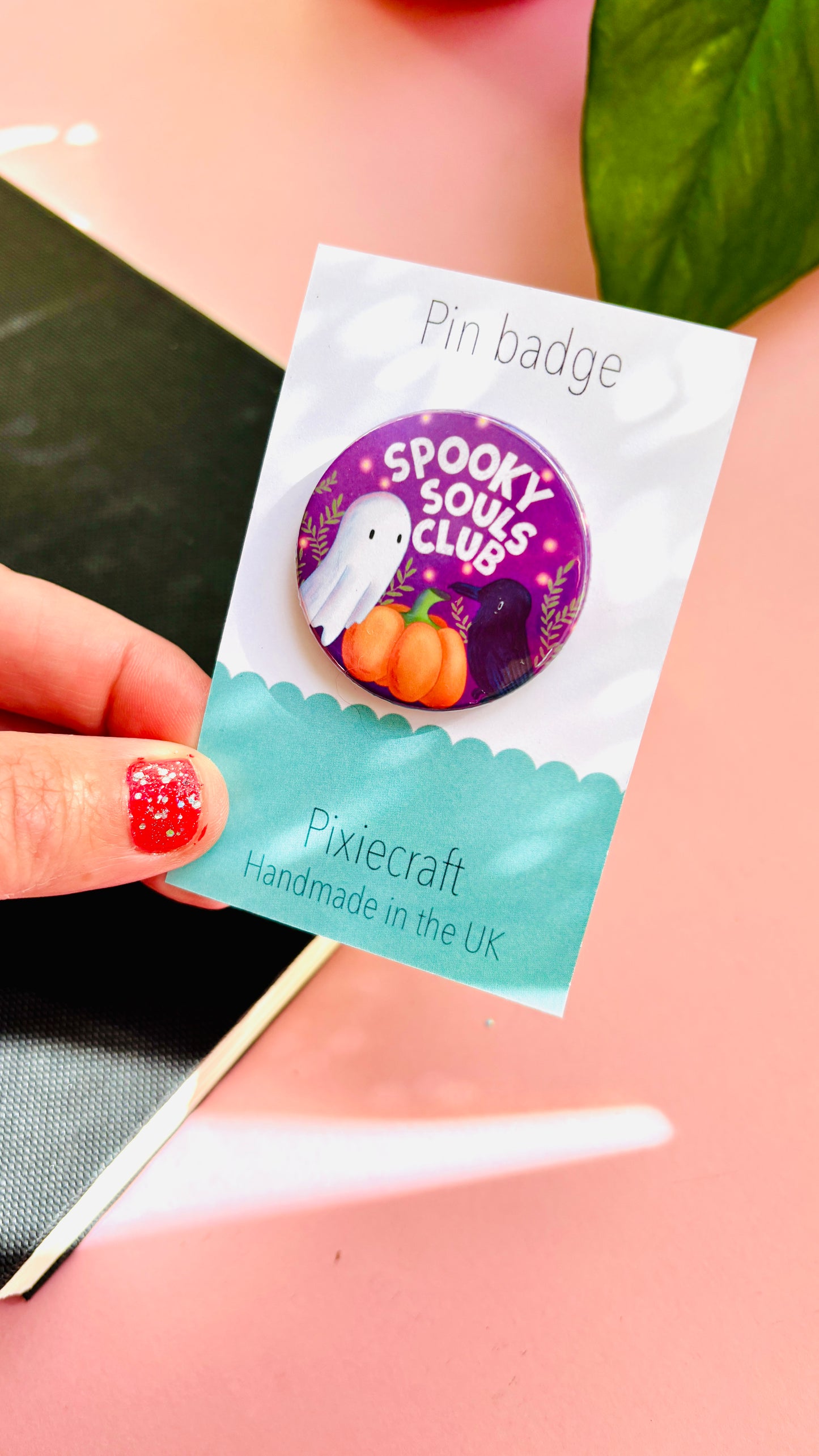 Cute Halloween accessory pin badge that reads “Spooky souls club” above a cute ghost, pumpkin and raven. A 38mm round pin presented on a backing card this badge or magnet is a great gift for Halloween treats, alt style accessories, witchy aesthetics.