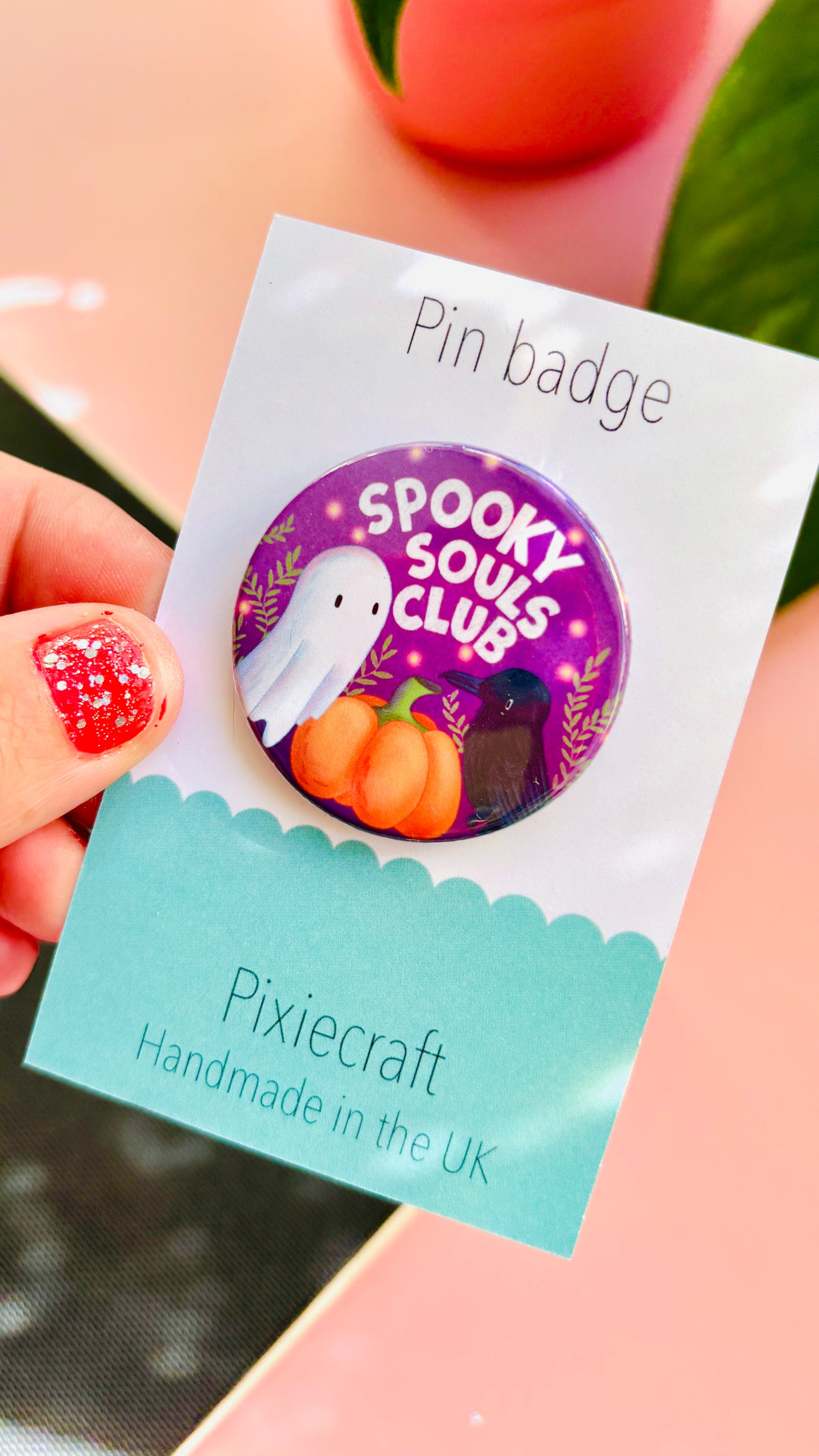 Cute Halloween accessory pin badge that reads “Spooky souls club” above a cute ghost, pumpkin and raven. A 38mm round pin presented on a backing card this badge or magnet is a great gift for Halloween treats, alt style accessories, witchy aesthetics.