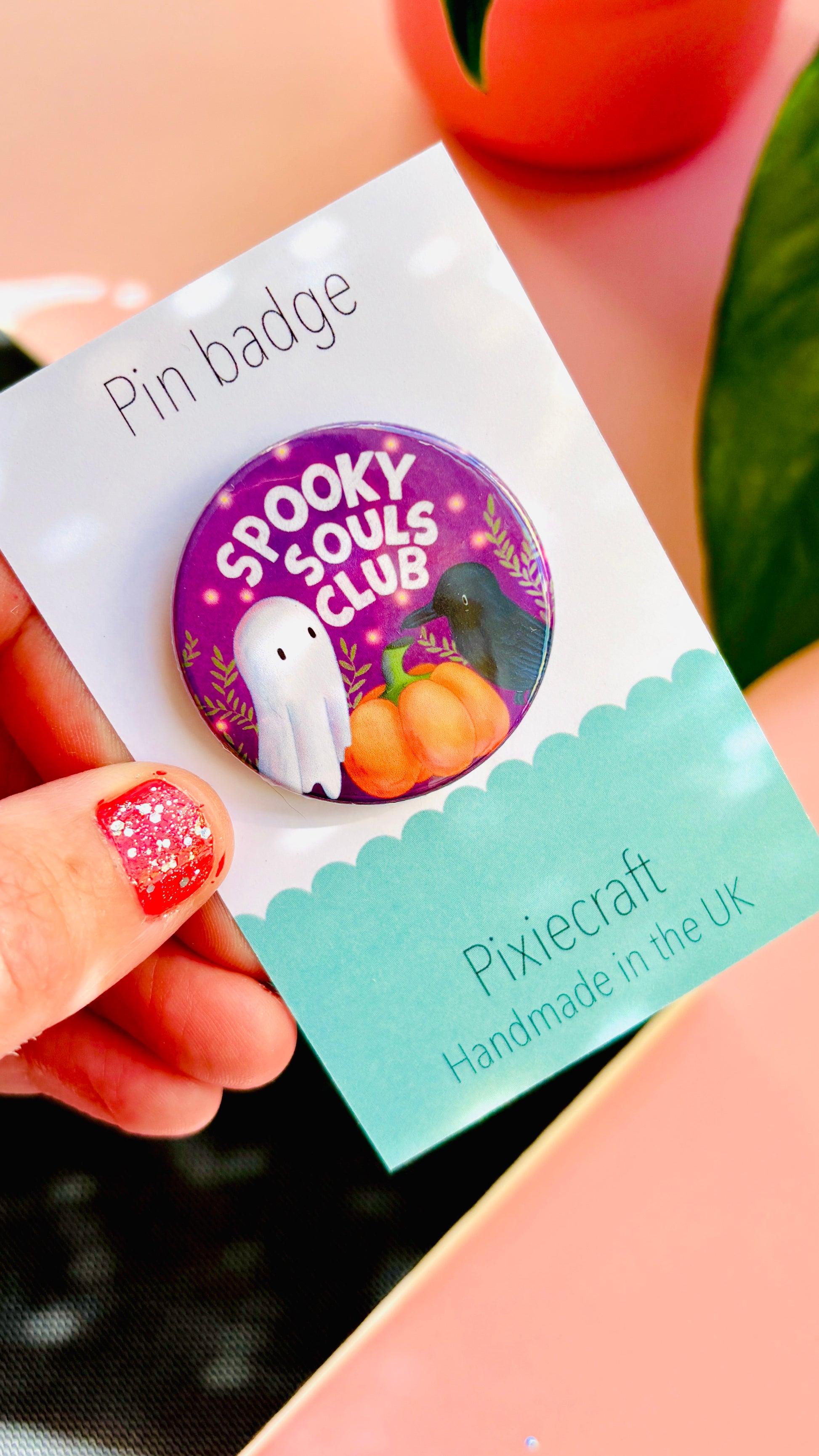 Cute Halloween accessory pin badge that reads “Spooky souls club” above a cute ghost, pumpkin and raven. A 38mm round pin presented on a backing card this badge or magnet is a great gift for Halloween treats, alt style accessories, witchy aesthetics.