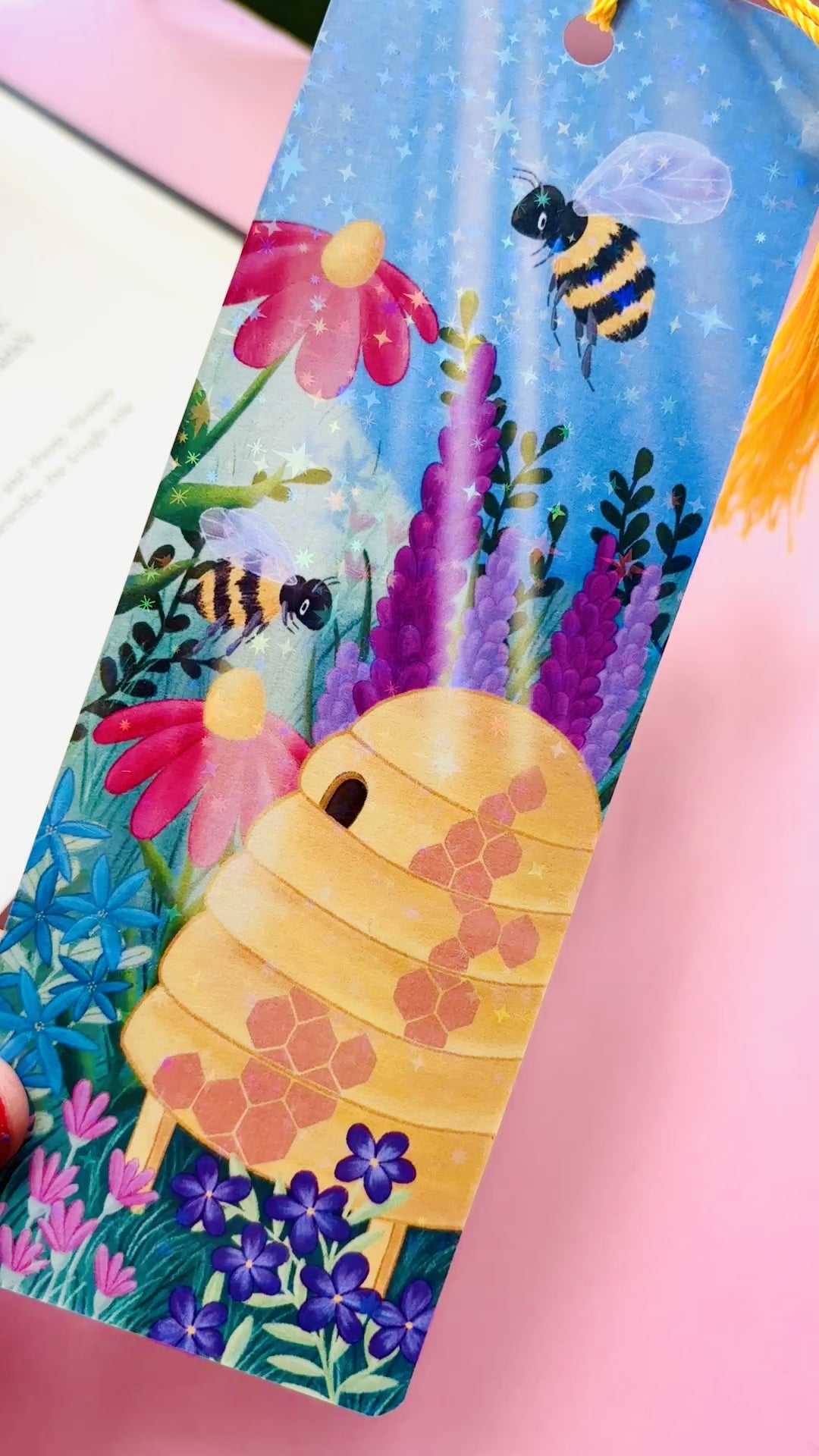 Handmade bee and wildflower bookmark with rainbow holographic finish, featuring playful bees and a colourful meadow, perfect for book lovers and nature enthusiasts