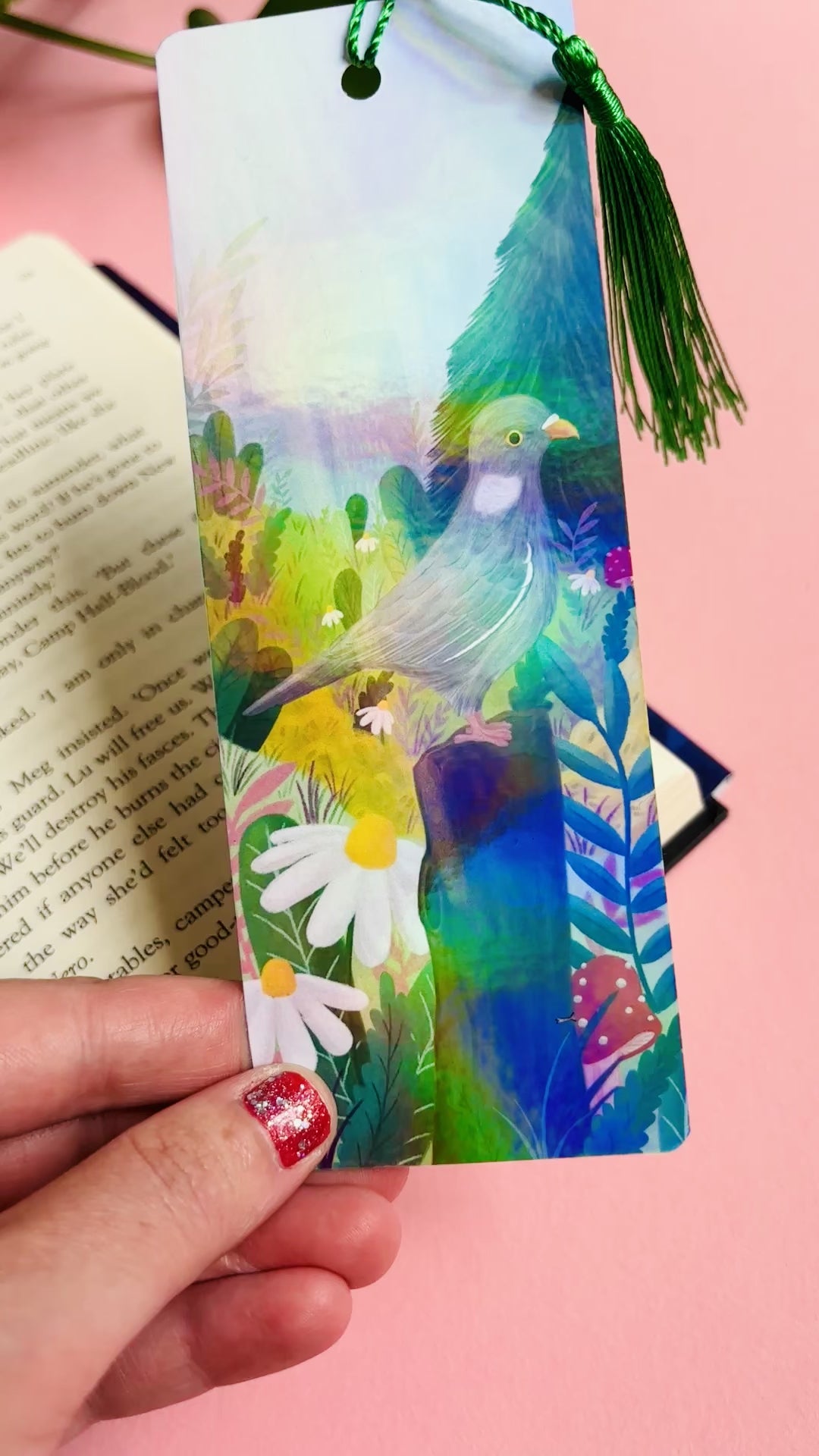 Handmade bookmark with cute pigeon art. This holographic bookmark features an adorable wood pigeon sitting on a mossy tree stump surrounded by colourful plants and flowers with a subtle cityscape in the background. Finished with a tassel, rounded corners and rainbow holographic laminate it makes a great gift for pigeon lovers and bookish besties.