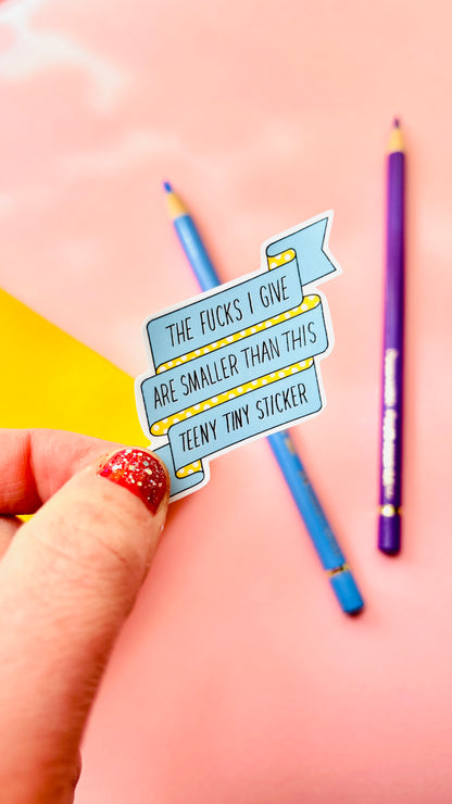 Sweary vinyl sticker quote that says “the fucks I give are smaller than this teeny tiny sticker” 