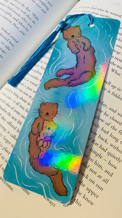 Otter bookmark with rainbow holographic laminate and a tassel 