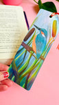 Handmade bookmark with a beautiful illustration of a kingfisher bird in the reads. This holographic bookmark has a rainbow laminate finish, tassel and rounded corners. Ideal for bookish gifts and nature lovers. 