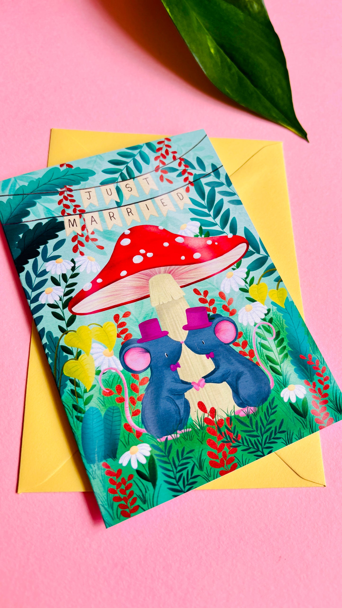 Cute gay wedding card of two mice under a whimsical toadstool in a vibrant woodland setting full of flowers and plants. This handmade card is blank on the inside for your message a d supplied with a yellow envelope 
