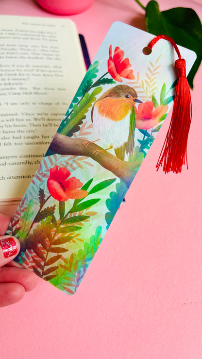 Handmade bookmark with a beautiful hand drawn illustration of a robin sitting among poppies. Finished with a rainbow holographic laminate, rounded corners and a tassel. The symbols of remembrance make this bookmark a thoughtful grief gift or way or remembering lost loved ones. 