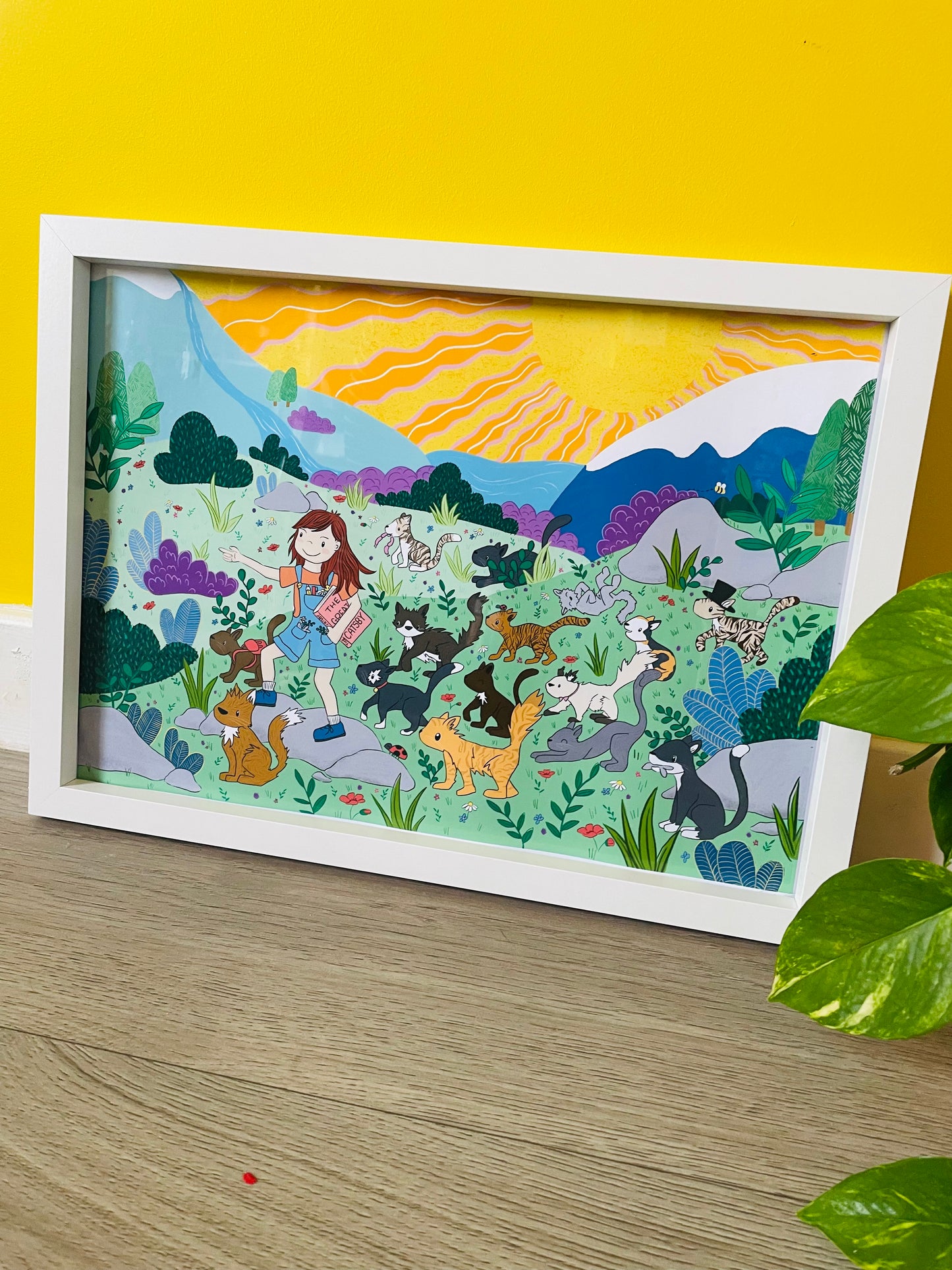 Colourful wall art illustration of a girl adventuring with a group of cats 