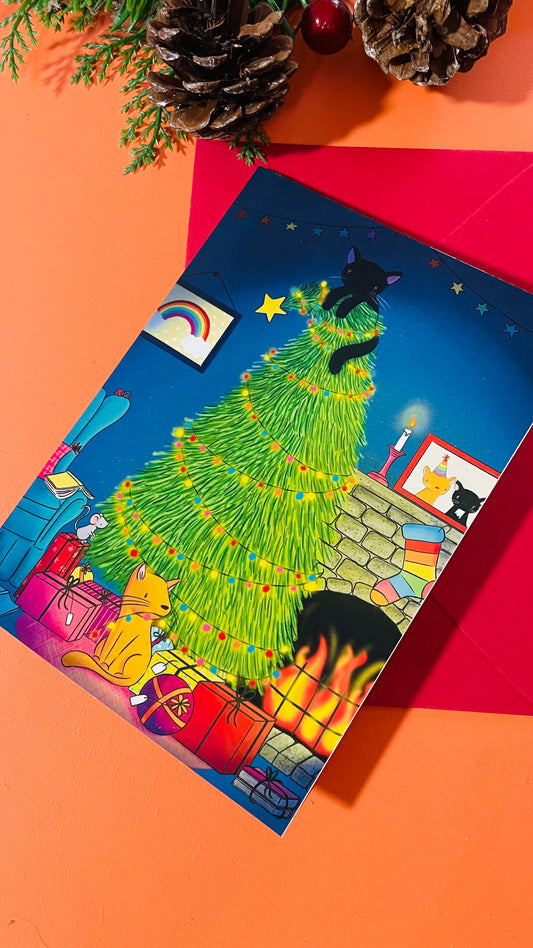 Illustrated card of two cats by a fire and a glowing, twinkly Christmas tree