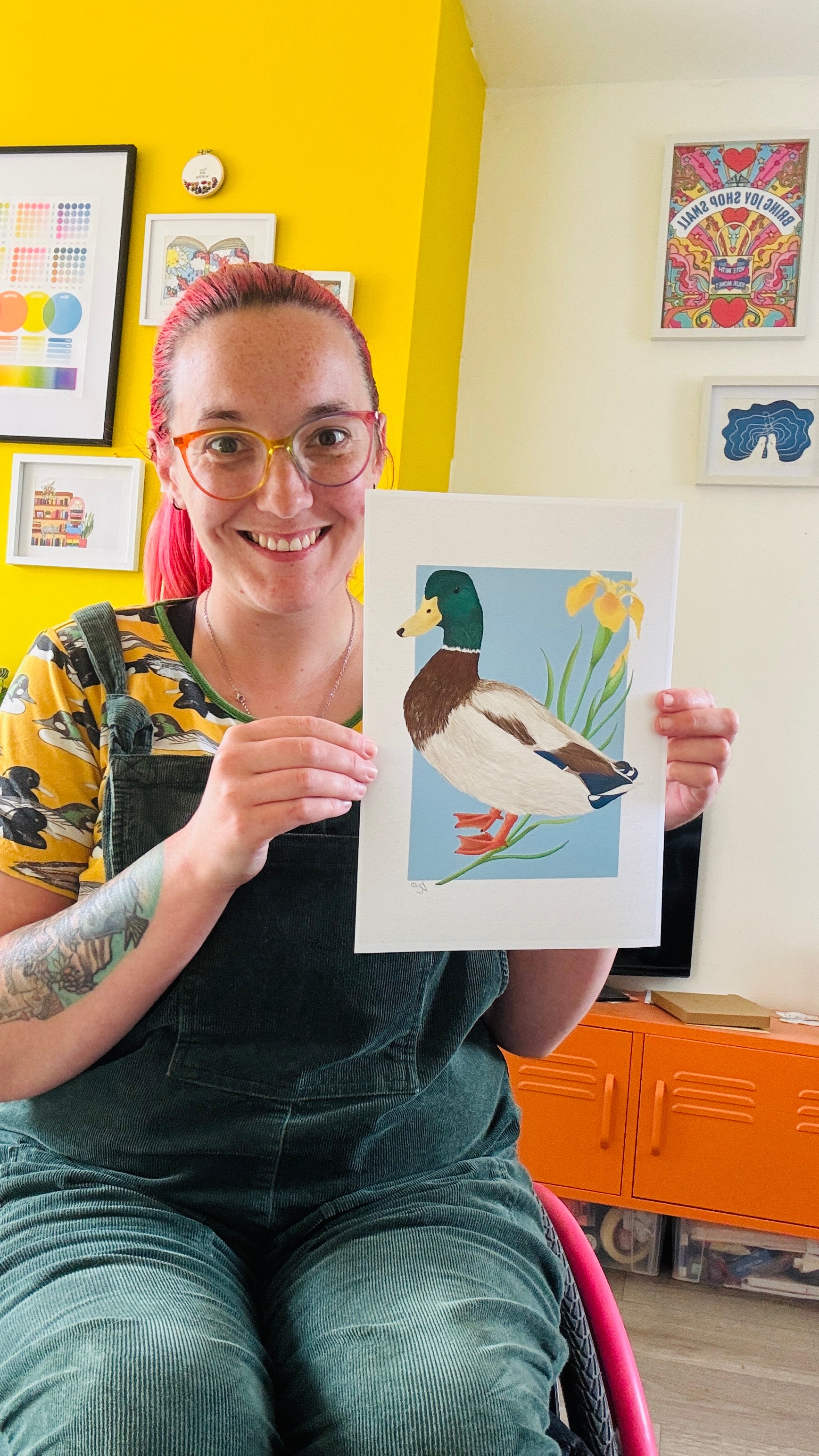 A detailed illustration of a mallard duck and vibrant yellow iris flower set against a vibrant blue background the duck art print is the perfect gift for nature lovers, fans of botanical art and cottagecore aesthetics.