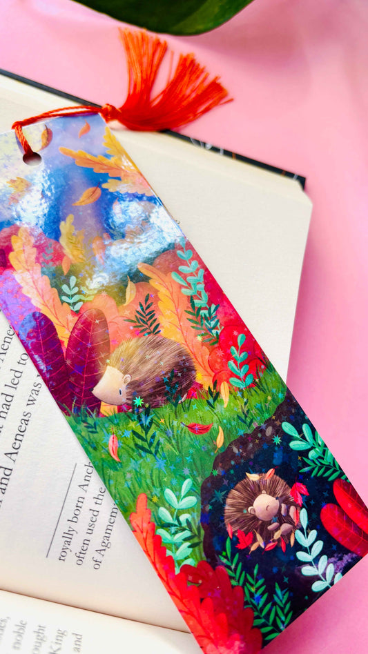 Hand-illustrated Autumn Hedgehog holographic bookmark, handmade in the UK. Rainbow shimmer finish with a tassel, perfect for marking pages in books, journals, or planners.
