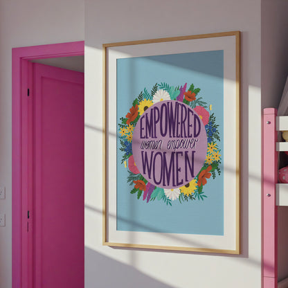 Feminist art print that reads “empowered women empower women” surround by colourful flowers and sets against a blue background. Inspirational wall art for women. 