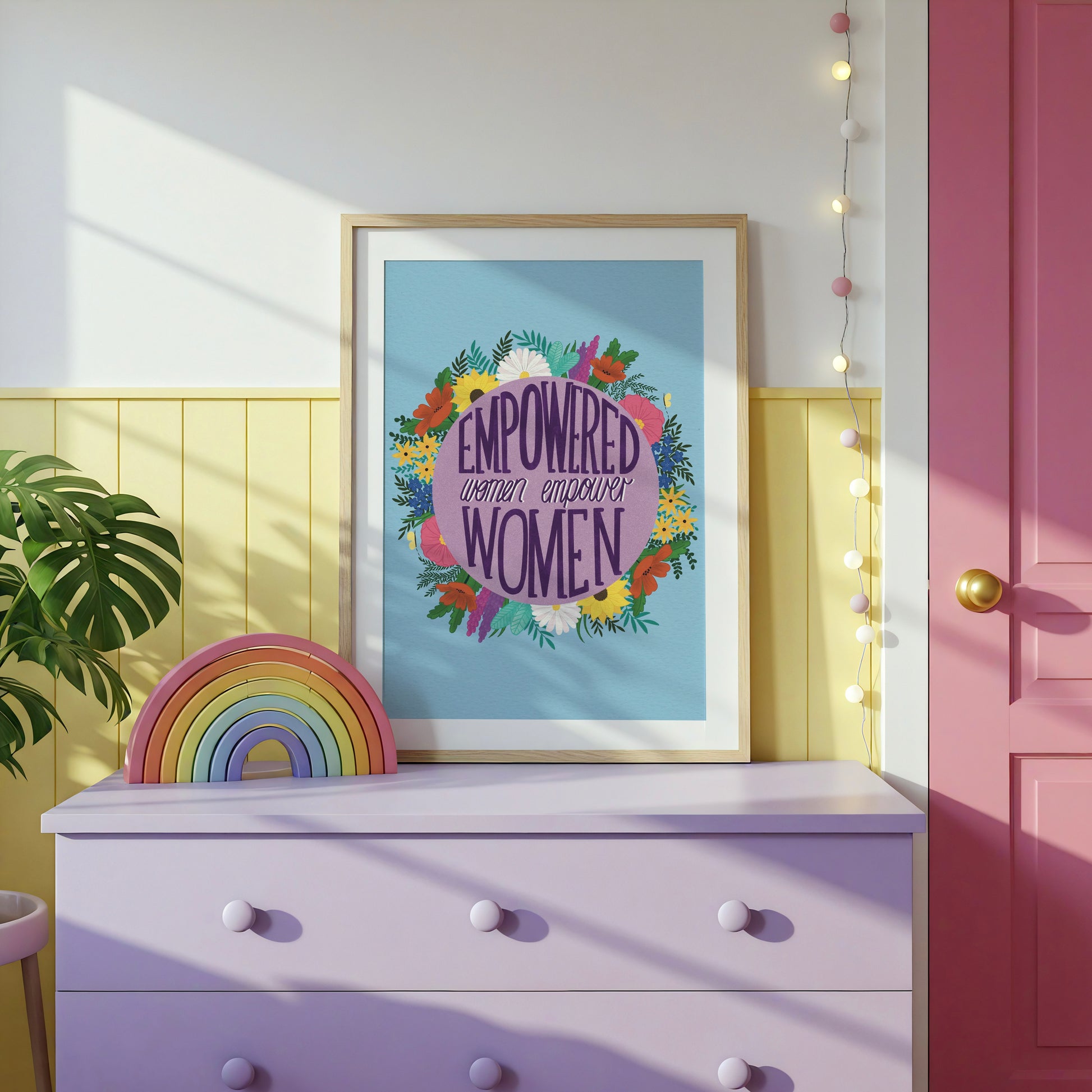 Feminist art print that reads “empowered women empower women” surround by colourful flowers and sets against a blue background. Inspirational wall art for women. 