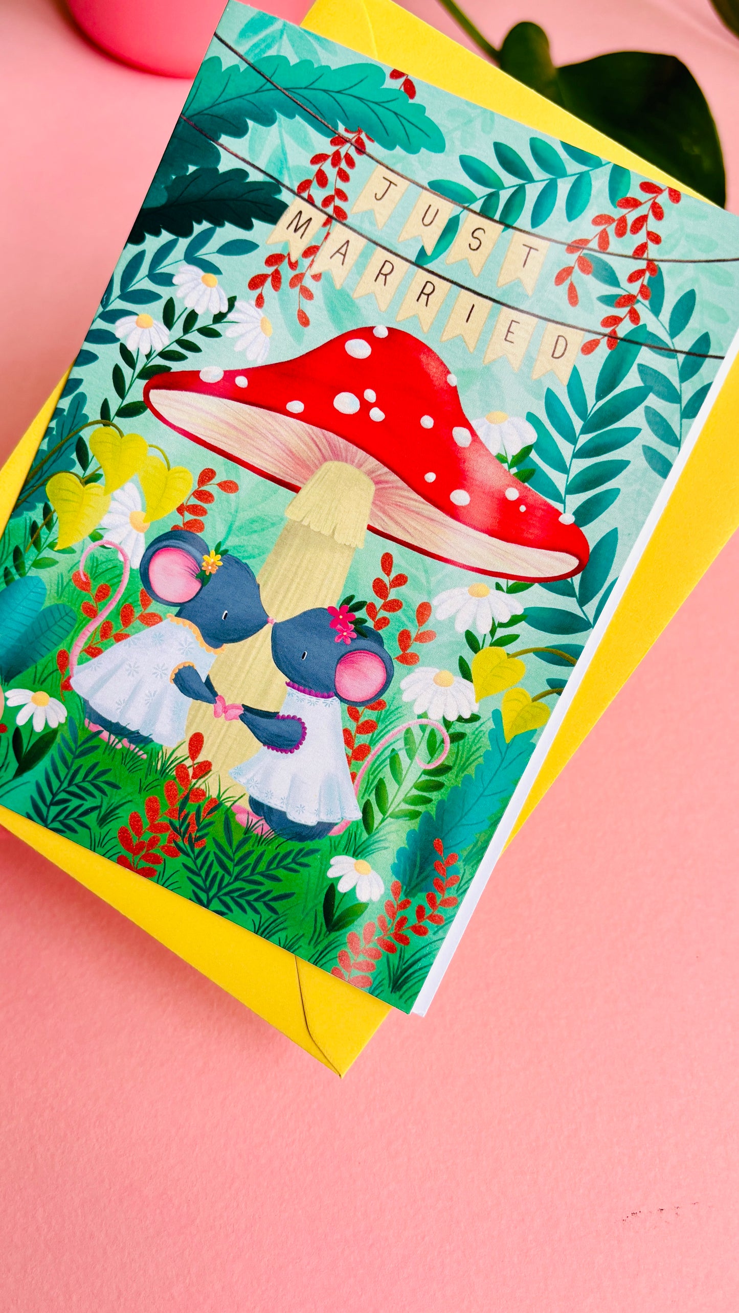 Handmade lesbian wedding card of two mice under a whimsical toadstool in a vibrant woodland setting full of flowers and plants. This handmade card is blank on the inside for your message a d supplied with a yellow envelope 
