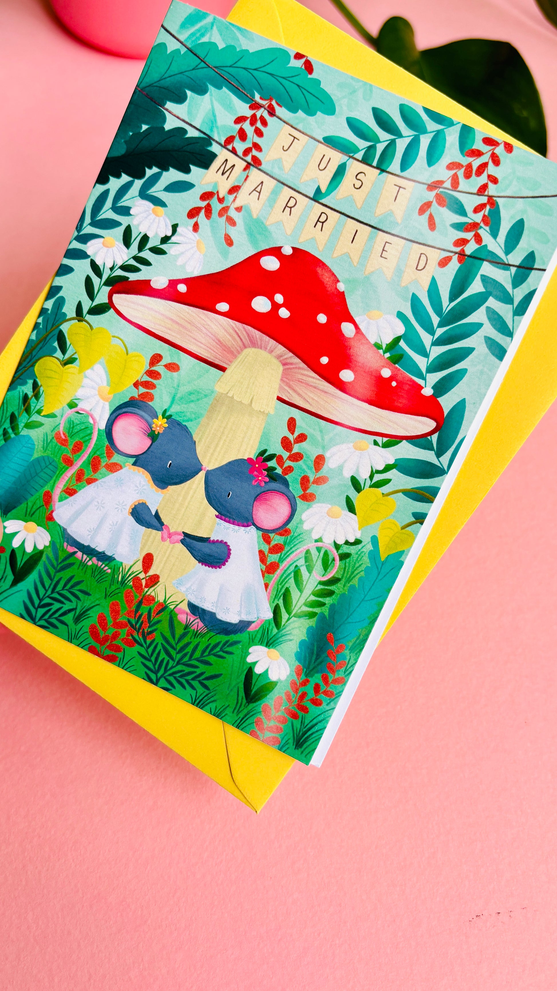 Handmade lesbian wedding card of two mice under a whimsical toadstool in a vibrant woodland setting full of flowers and plants. This handmade card is blank on the inside for your message a d supplied with a yellow envelope 