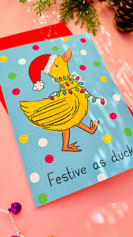 Funny Christmas card with a yellow duck in a Santa hat tangled in fairy lights, bold “Festive as Duck” design for friends and family.
