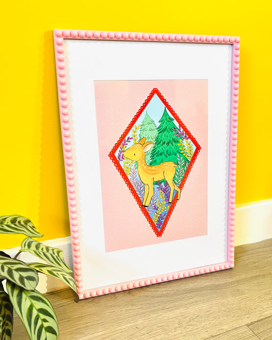 a colourful art print of a deer on a soft pink background surrounded by forestry plants and trees