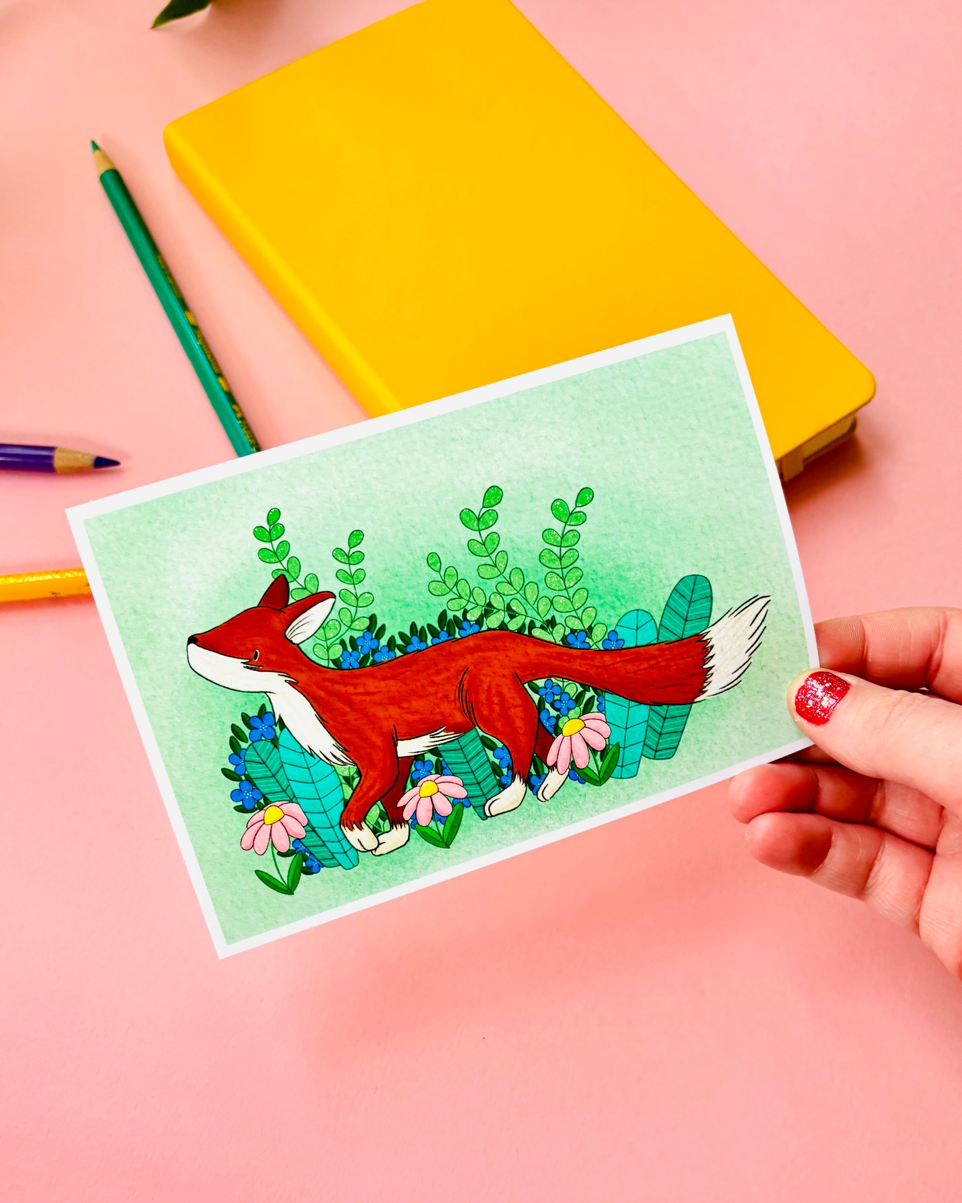 a mini art print of a charming red fox nestled in front of the spring plants and flowers on a green background