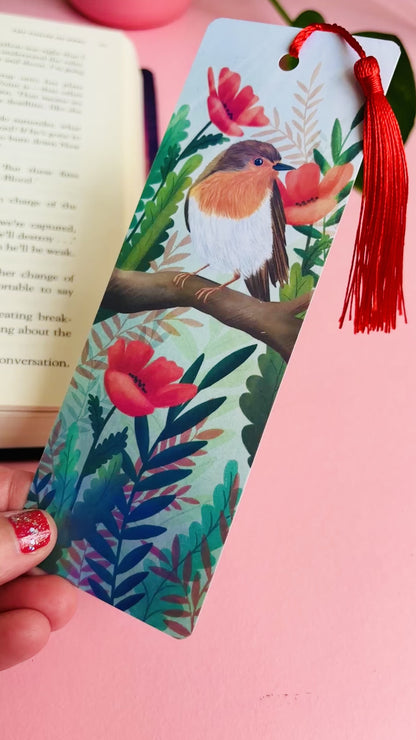 Handmade bookmark with a beautiful hand drawn illustration of a robin sitting among poppies. Finished with a rainbow holographic laminate, rounded corners and a tassel. The symbols of remembrance make this bookmark a thoughtful grief gift or way or remembering lost loved ones. 