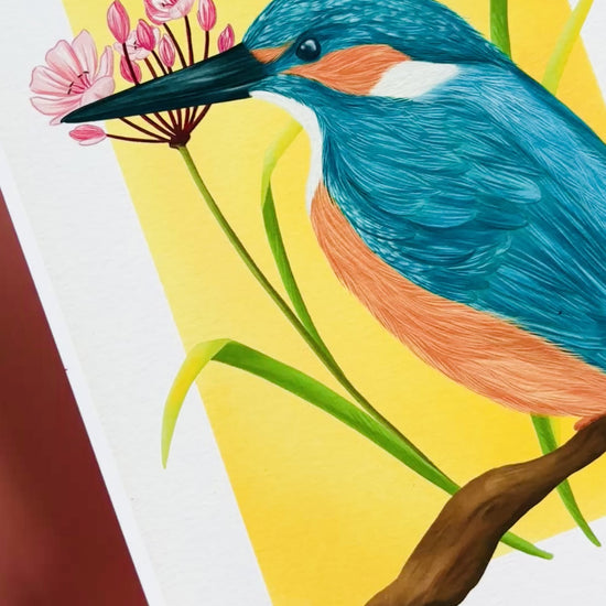 Kingfisher nature art print of a vibrant kingfisher bird and pink flowering rush plant inspired by British wildlife. Setting against a yellow backdrop this bold print is perfect for nature lovers and fans of maximalist decor.
