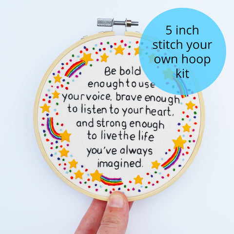 A 5 inch embroidery hoop reading "be bold enough to use your voice, brave enough to listen to your heart and strong enough to live the life you've always imagined". It is surrounded by shooting stars with rainbow tails, stars and rainbow french knots.
