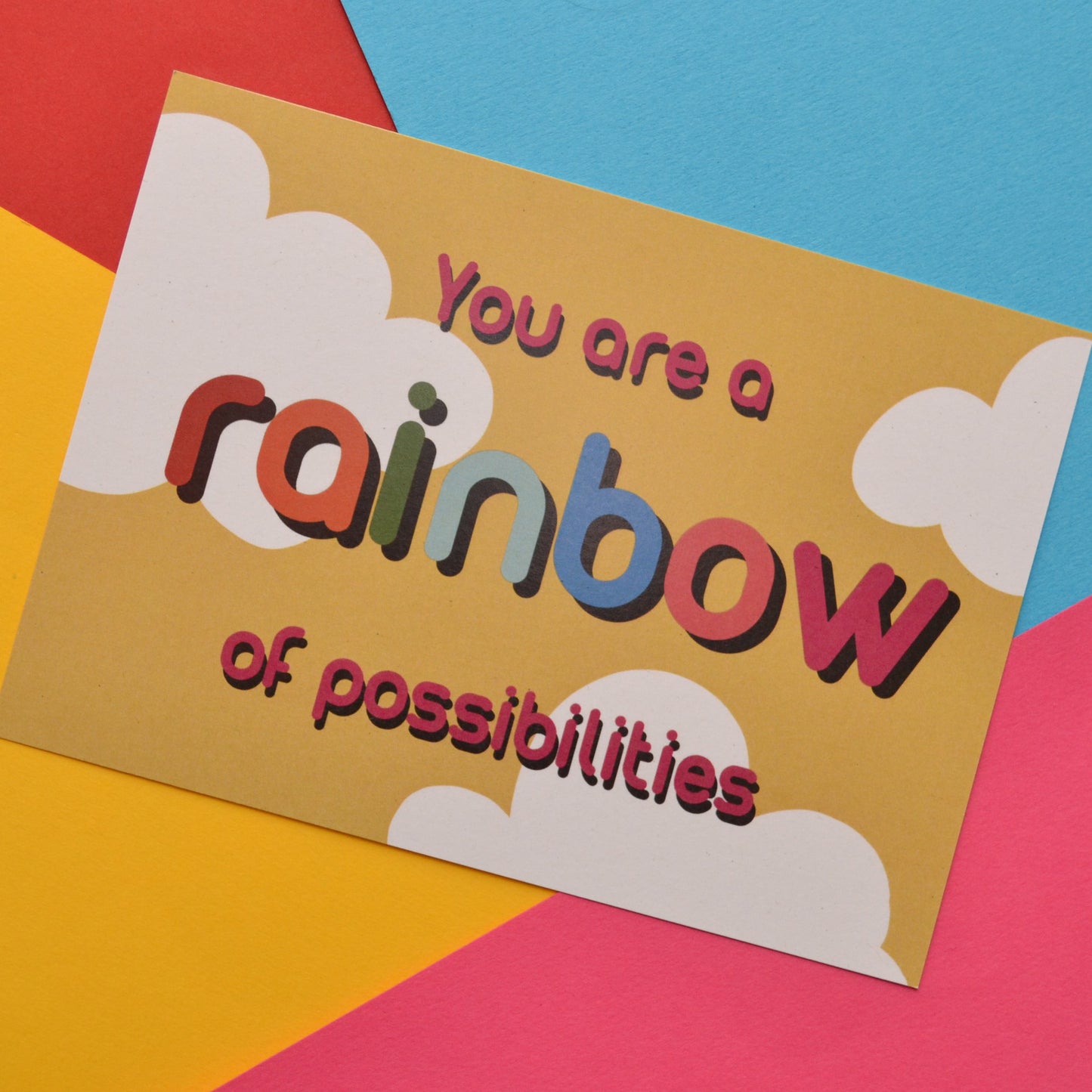 You are a rainbow of possibilities postcard in red and rainbow colours on a yellow and white cloud background