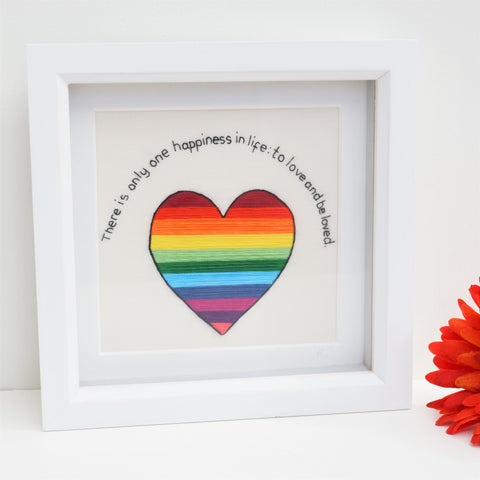 A hand embroidered rainbow striped heart and the text reads There is only one happiness in life: to love and be loved